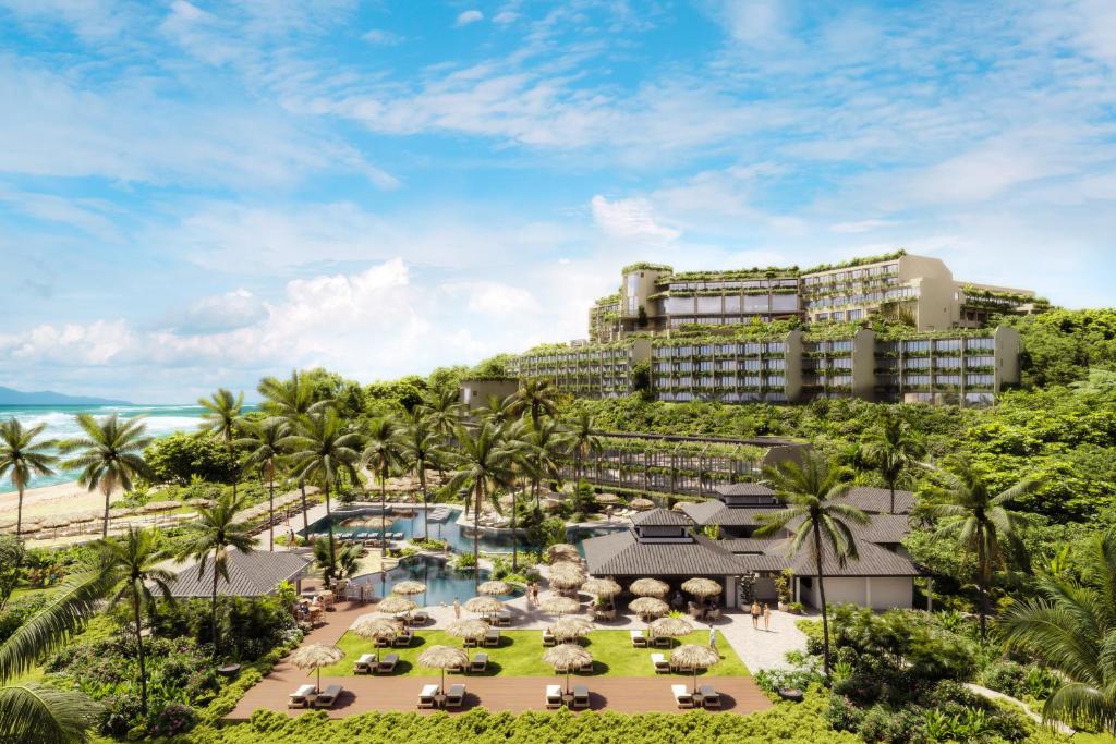 vista panorâmica de resort com piscinas, coqueiros e prédio ao fundo