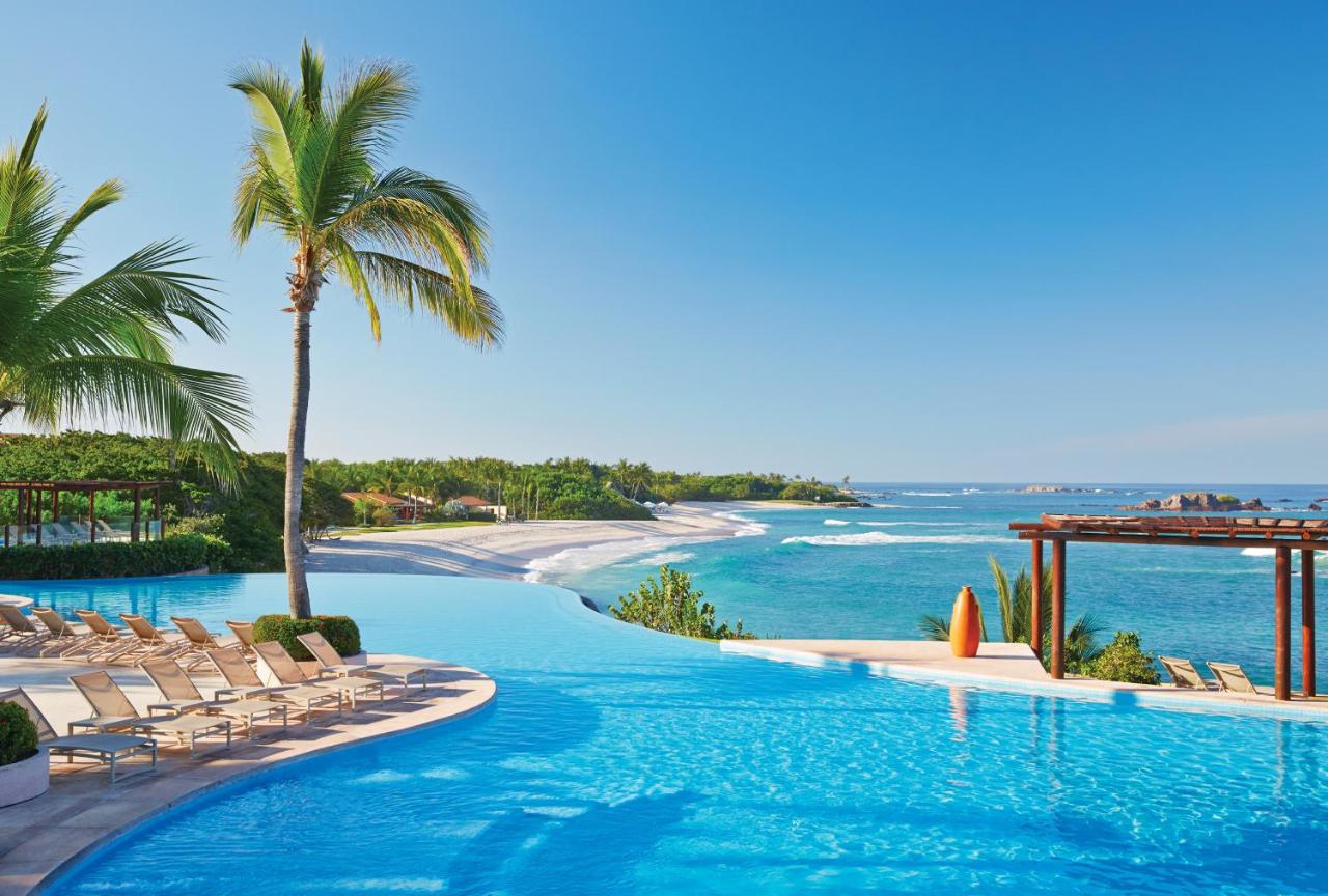 grande piscina com espreguiçadeiras e vista para o mar