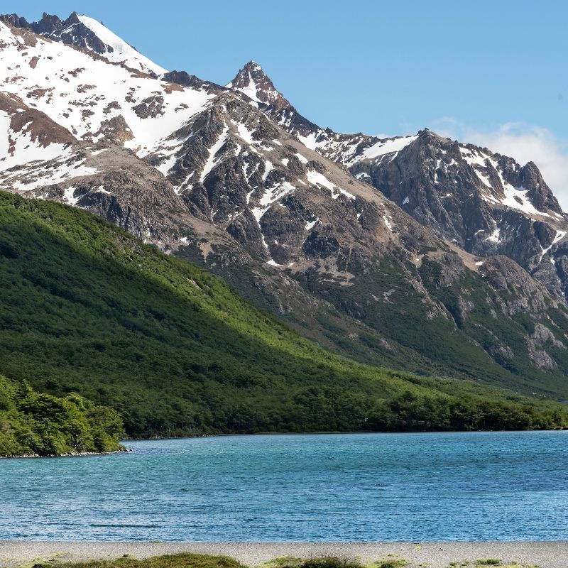 montanha com neve e lagoa azul a frente